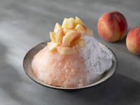 Luxurious shaved ice with melting white peaches and almond espuma topping