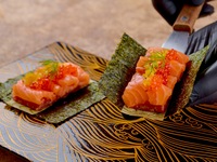 個室確約【姉妹店 銀座ちかみつ焼肉百名店2025受賞記念コース】「厳選和牛とサーモンのユッケドッグ」「メンチカツカツサンド」「白いフリージング冷麺」を含む厳選された焼き物7種をご提供。